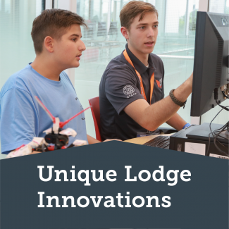 Two scouts working on a project with a computer.